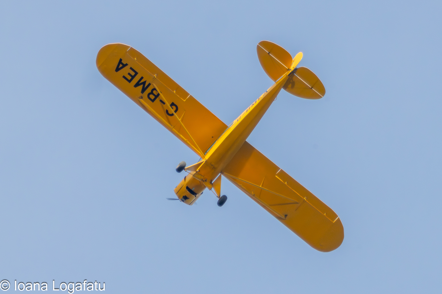 Yellow plane flying in blue sky